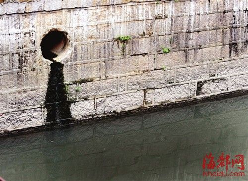 內(nèi)河一處排污口，正在流出墨黑色污水。